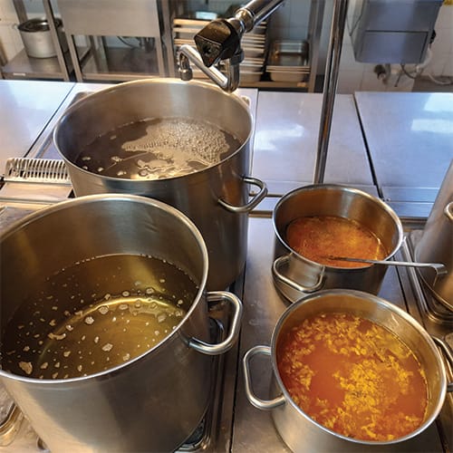 Four pots on a stove ready to cook meals